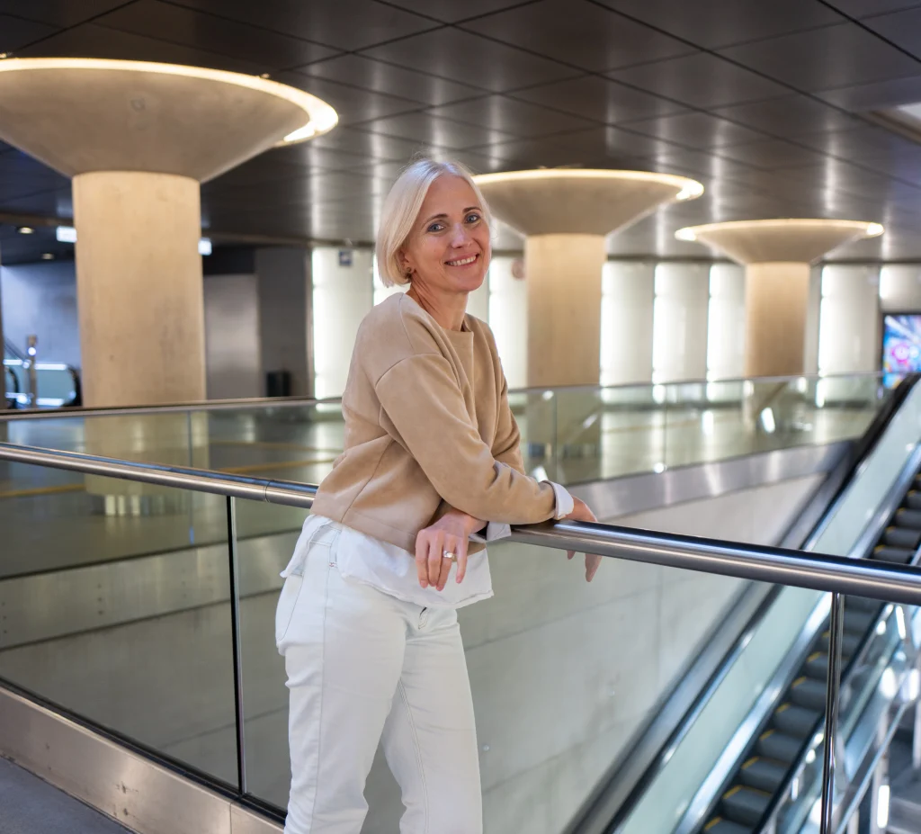 Milda Račiūnaitė šypsosi, atsirėmusi į turėklą.