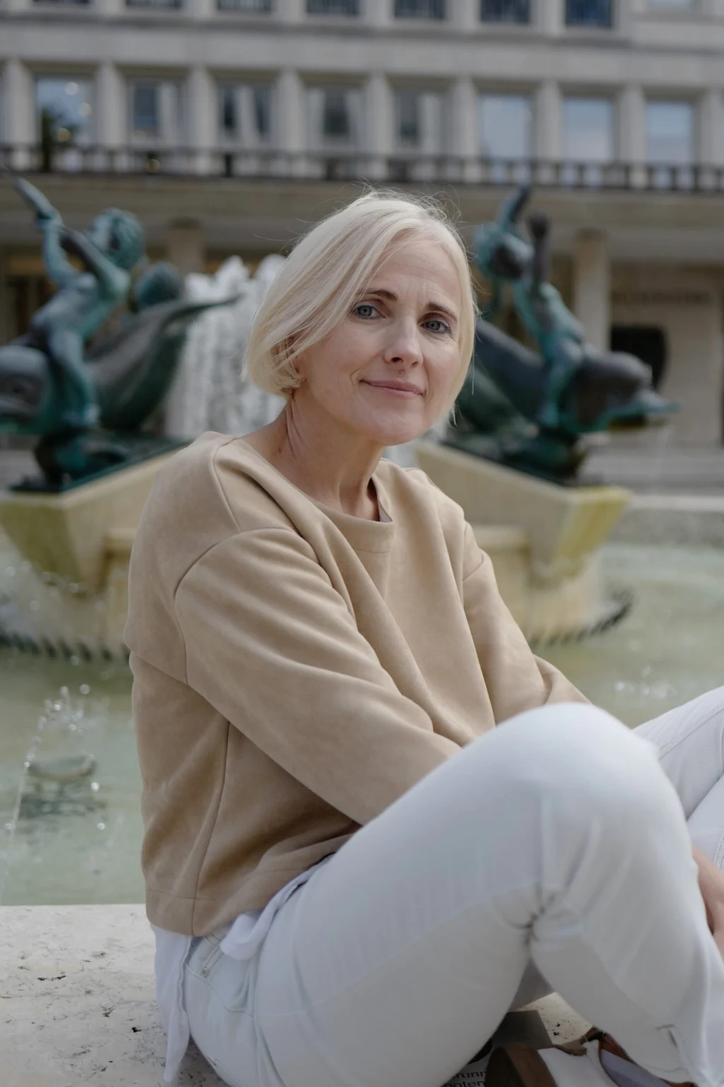 Milda Račiūnaitė sėdi prie fontano.